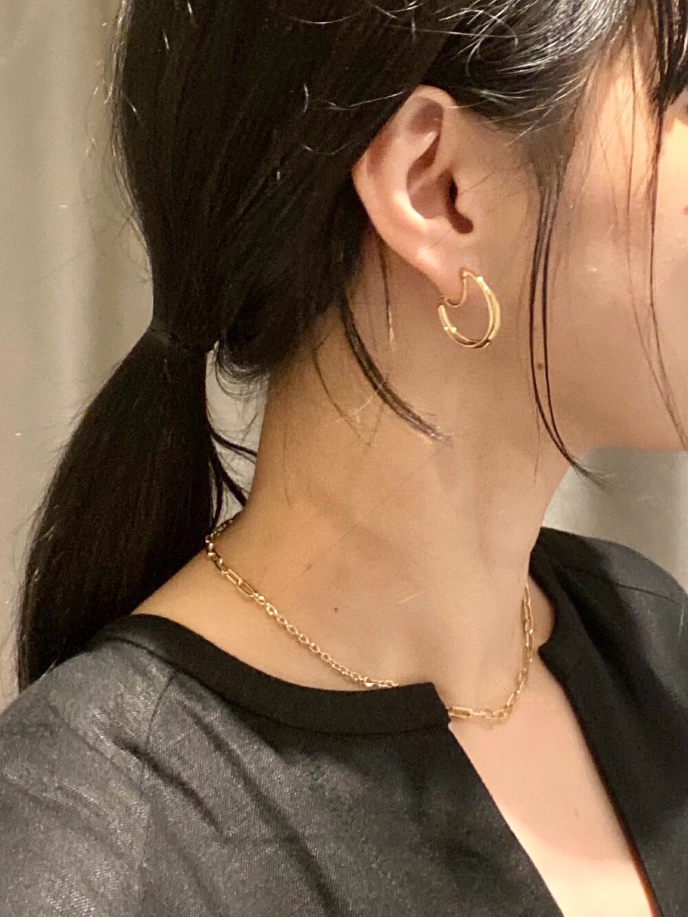 ゴールド系のイヤリング、ゴールド系のネックレス、シルバー系のリングを着用したレディースの夏コーディネートの3枚目の写真