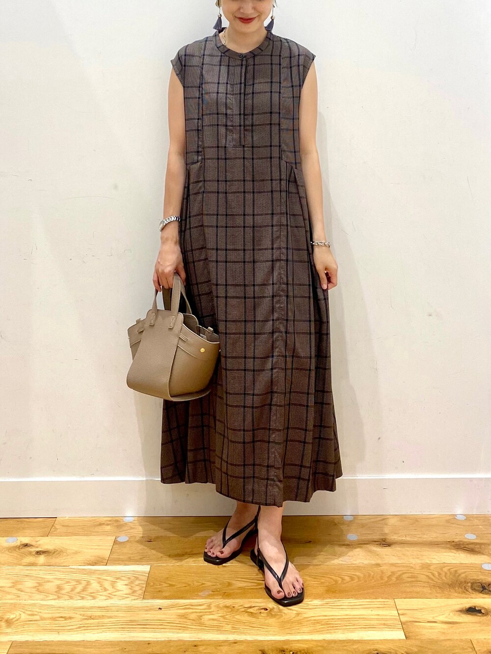 ブラウン系のワンピース、ブラウン系のハンドバッグ、ブラック系のサンダルを着用したレディースの夏コーディネートの4枚目の写真