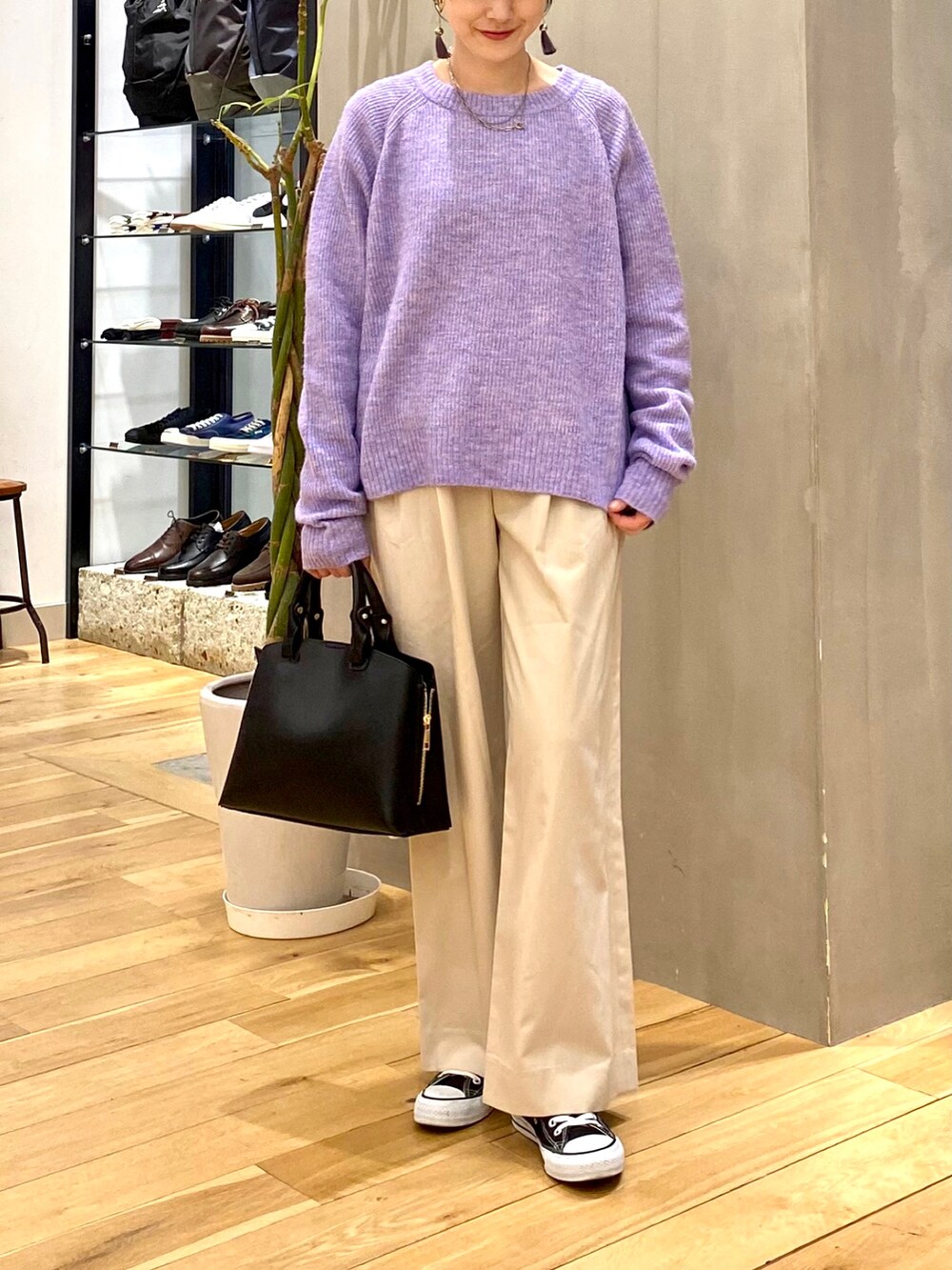 パープル系のニット/セーター、ホワイト系のその他パンツ、ブラック系のトートバッグを着用したレディースの冬コーディネートの4枚目の写真