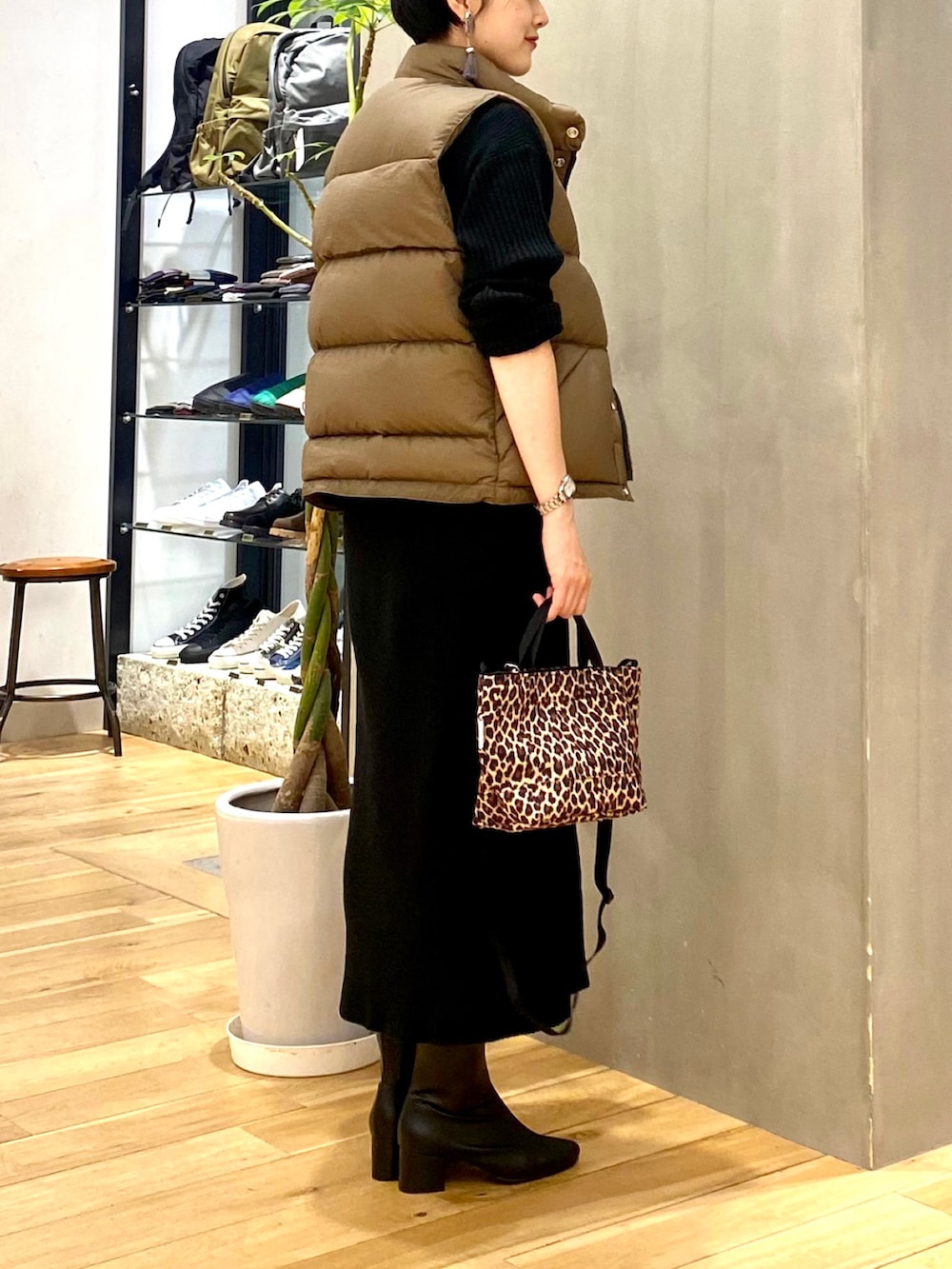 ベージュ系のダウンベスト、ブラック系のワンピース、その他のショルダーバッグを着用したレディースの秋コーディネートの5枚目の写真