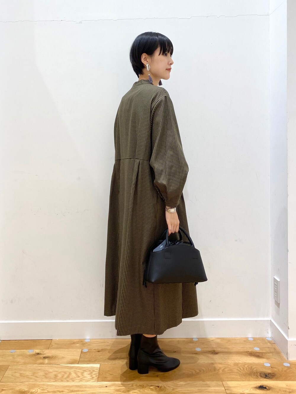 ブラウン系のステンカラーコート、その他のワンピース、ブラック系のショルダーバッグを着用したレディースの秋コーディネートの5枚目の写真