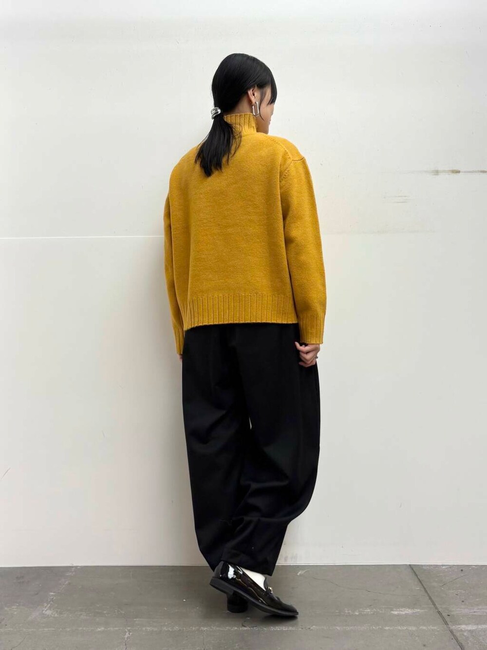 ブラック系のローファー、イエロー系のニット/セーター、ブラック系のその他パンツを着用したレディースの冬コーディネートの6枚目の写真