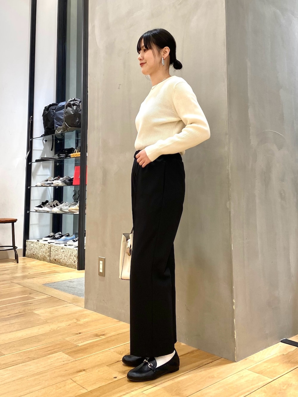ホワイト系のニット/セーター、ブラック系のその他パンツ、ホワイト系のトートバッグを着用したレディースの冬コーディネートの6枚目の写真