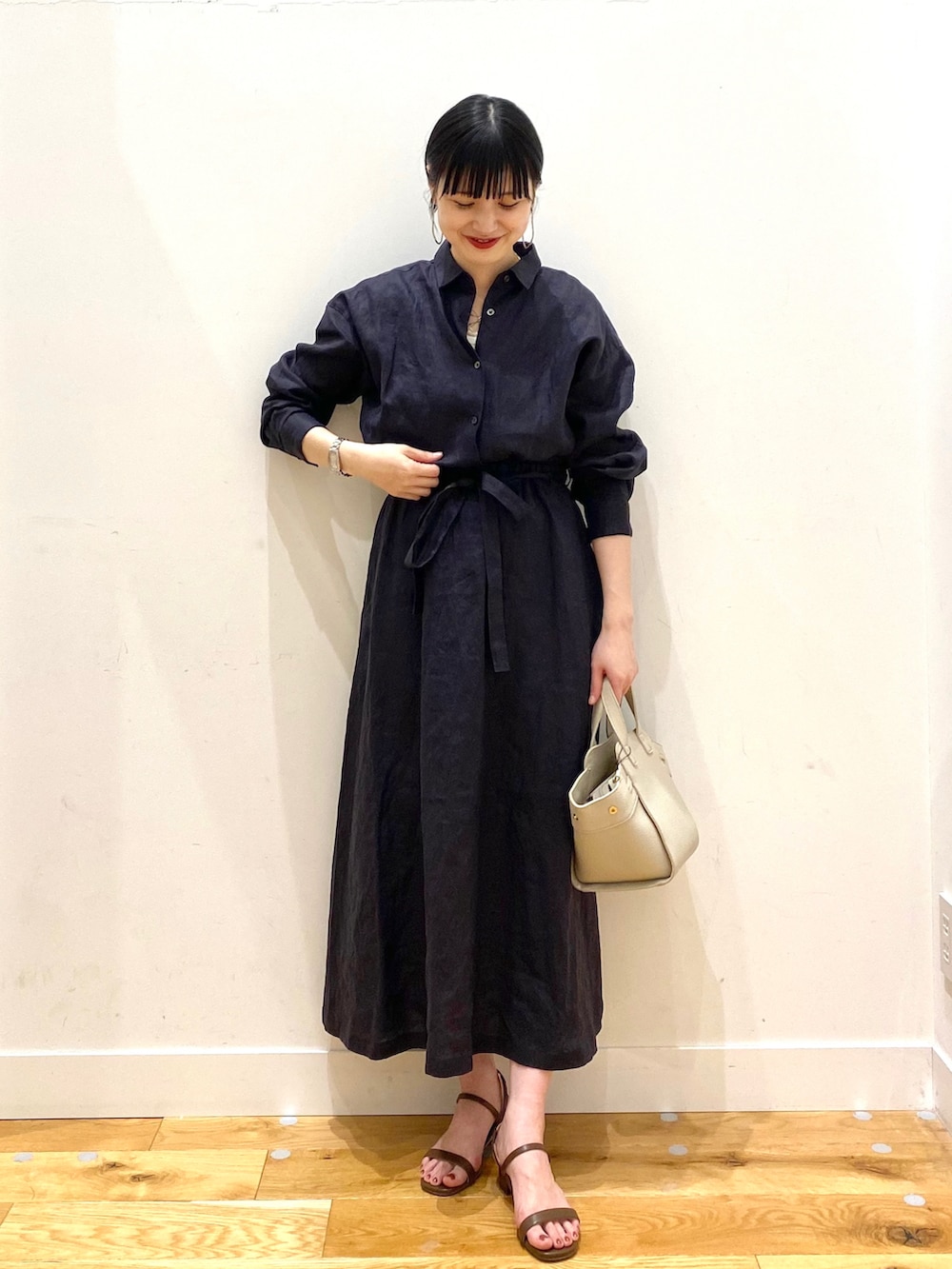 ブルー系のワンピース、ホワイト系のワンピース、ホワイト系のハンドバッグを着用したレディースの春コーディネートの2枚目の写真