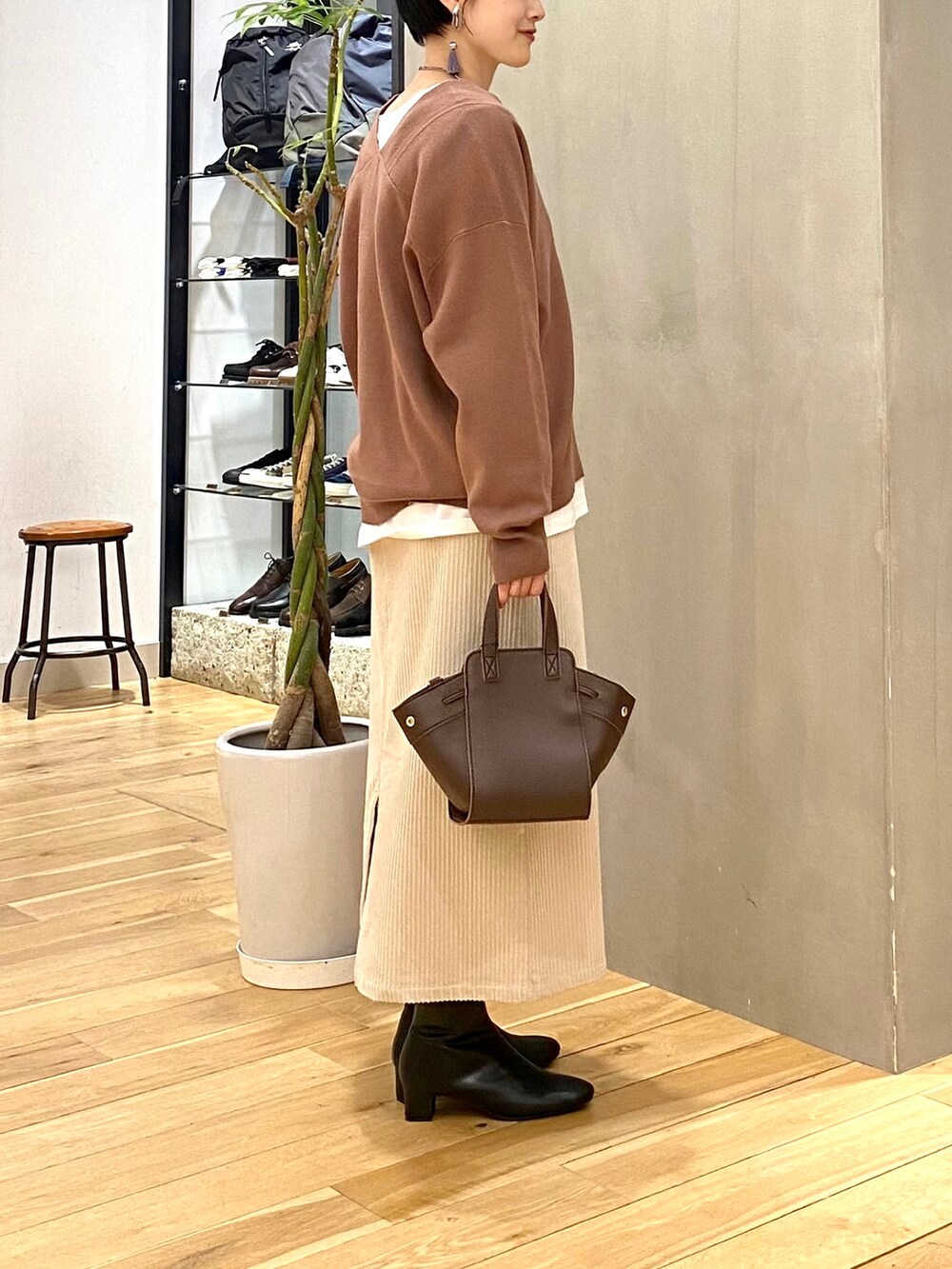 ブラウン系のニット/セーター、ホワイト系のTシャツ/カットソー、ホワイト系のスカートを着用したレディースの冬コーディネートの5枚目の写真