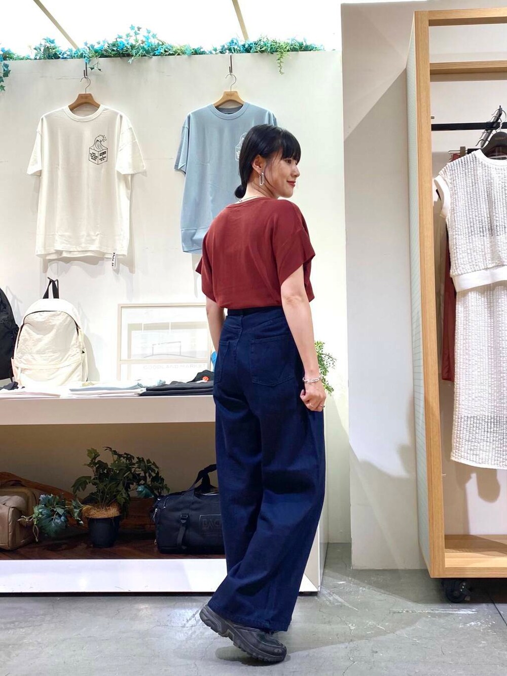 レッド系のニット/セーター、ブルー系のデニムパンツを着用したレディースの夏コーディネートの4枚目の写真
