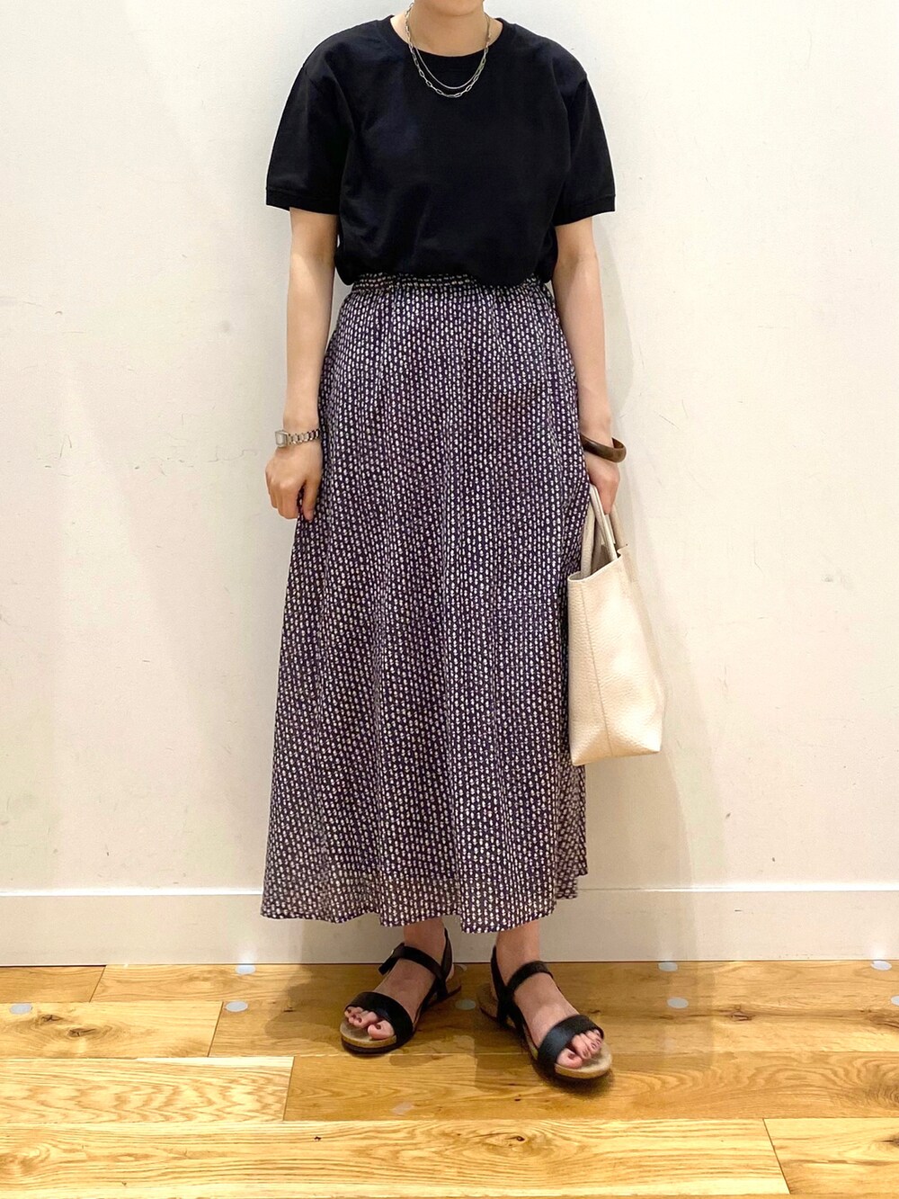 ブラック系のTシャツ/カットソー、グレー系のスカート、ホワイト系のトートバッグを着用したレディースの夏コーディネートの4枚目の写真