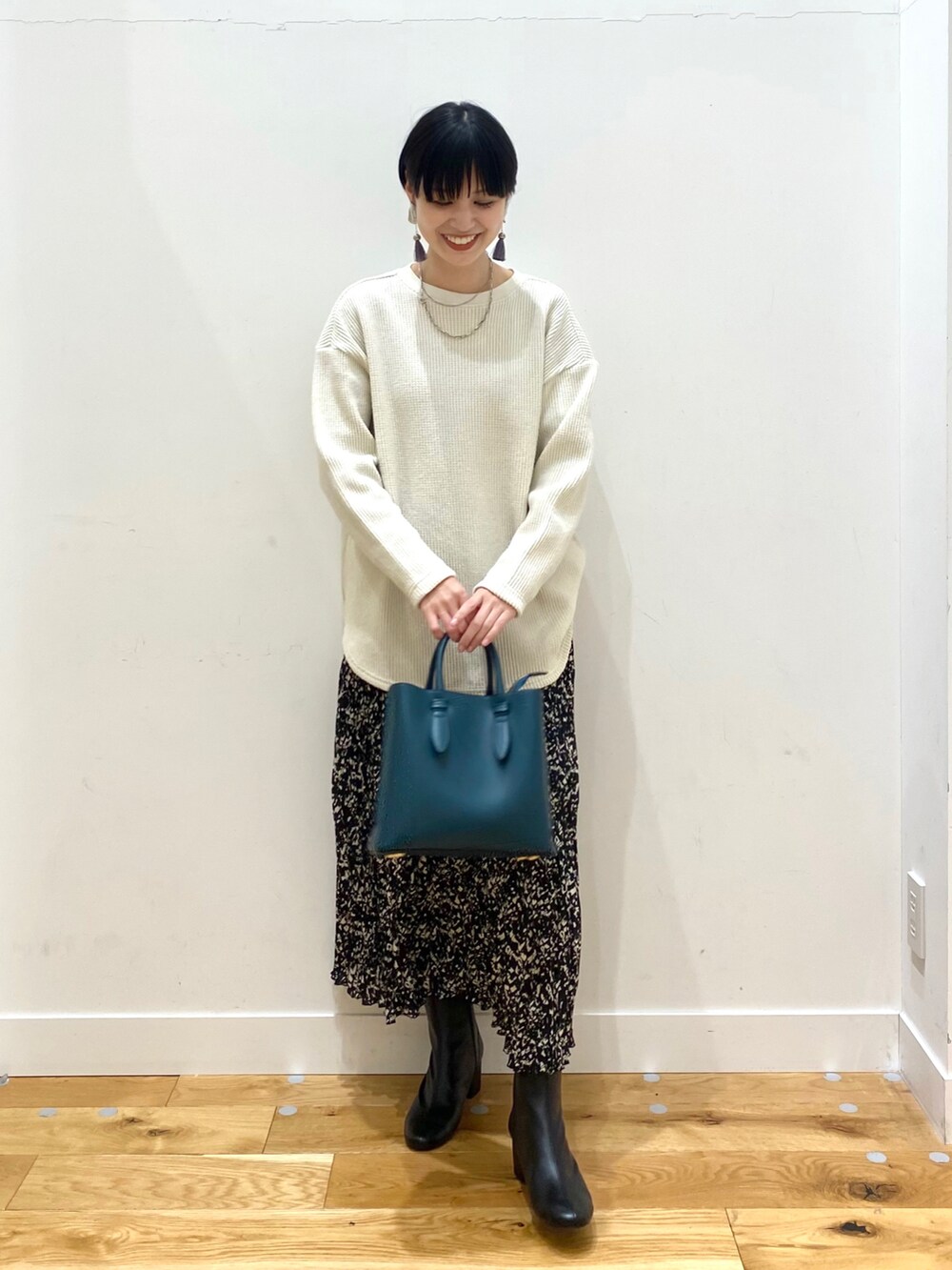 ブラウン系のステンカラーコート、ホワイト系のTシャツ/カットソー、ブラック系のスカートを着用したレディースの冬コーディネートの4枚目の写真