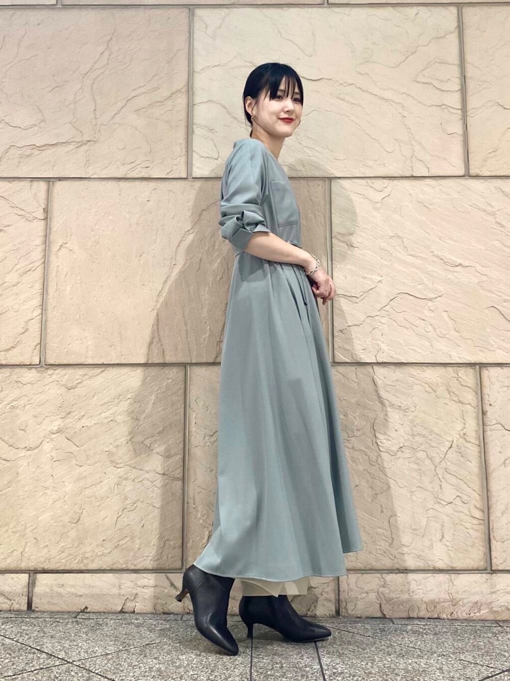 グリーン系のワンピース、ベージュ系のその他パンツ、ブラック系のブーツを着用したレディースの秋コーディネートの2枚目の写真