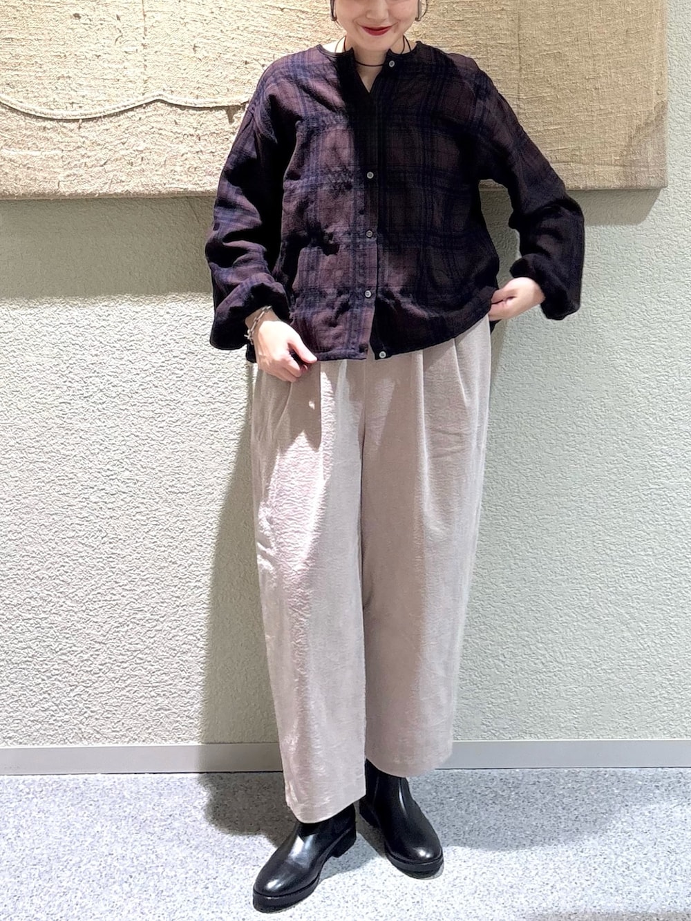 ブラウン系のカーディガン/ボレロ、グレー系のその他パンツ、ブラック系のブーツを着用したレディースの秋コーディネートの4枚目の写真