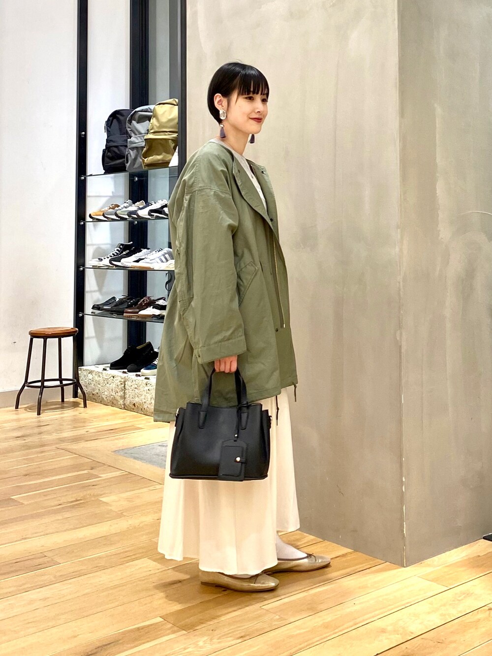 グリーン系のモッズコート、グレー系のスウェット、ホワイト系のスカートを着用したレディースの春コーディネートの2枚目の写真