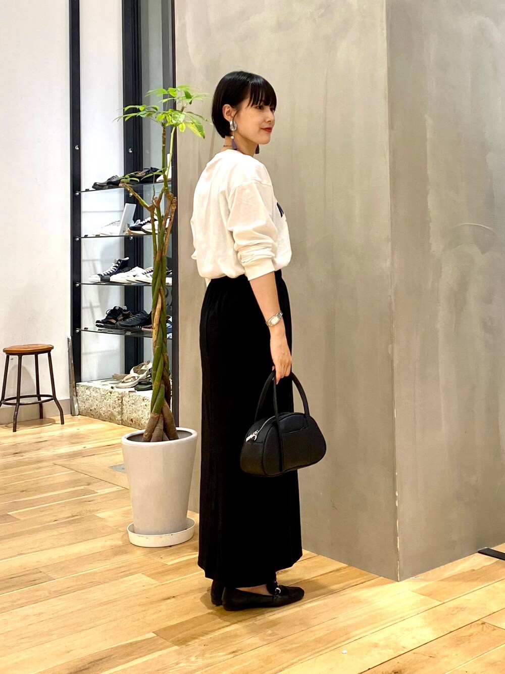 ホワイト系のTシャツ/カットソー、ブラック系のスカート、ブラック系のショルダーバッグを着用したレディースの秋コーディネートの4枚目の写真