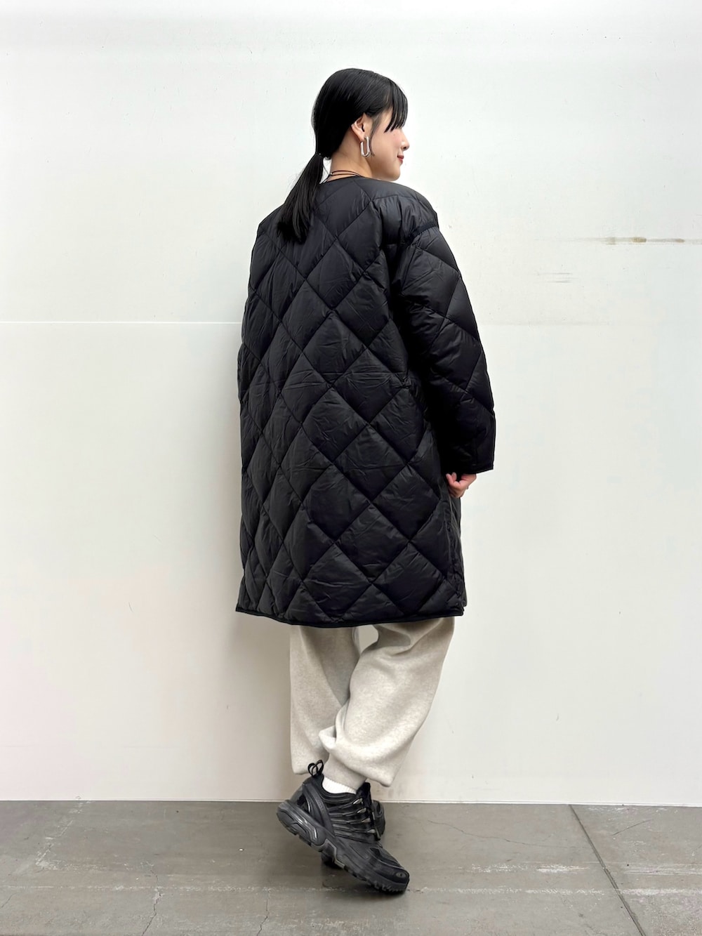 ブラック系のダウンジャケット/コート、ブルー系のニット/セーター、ベージュ系のニット/セーターを着用したレディースの冬コーディネートの3枚目の写真