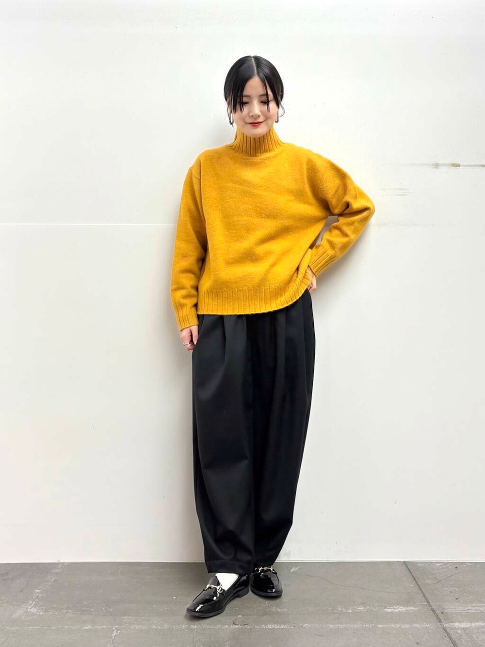 ブラック系のローファー、イエロー系のニット/セーター、ブラック系のその他パンツを着用したレディースの冬コーディネートの3枚目の写真