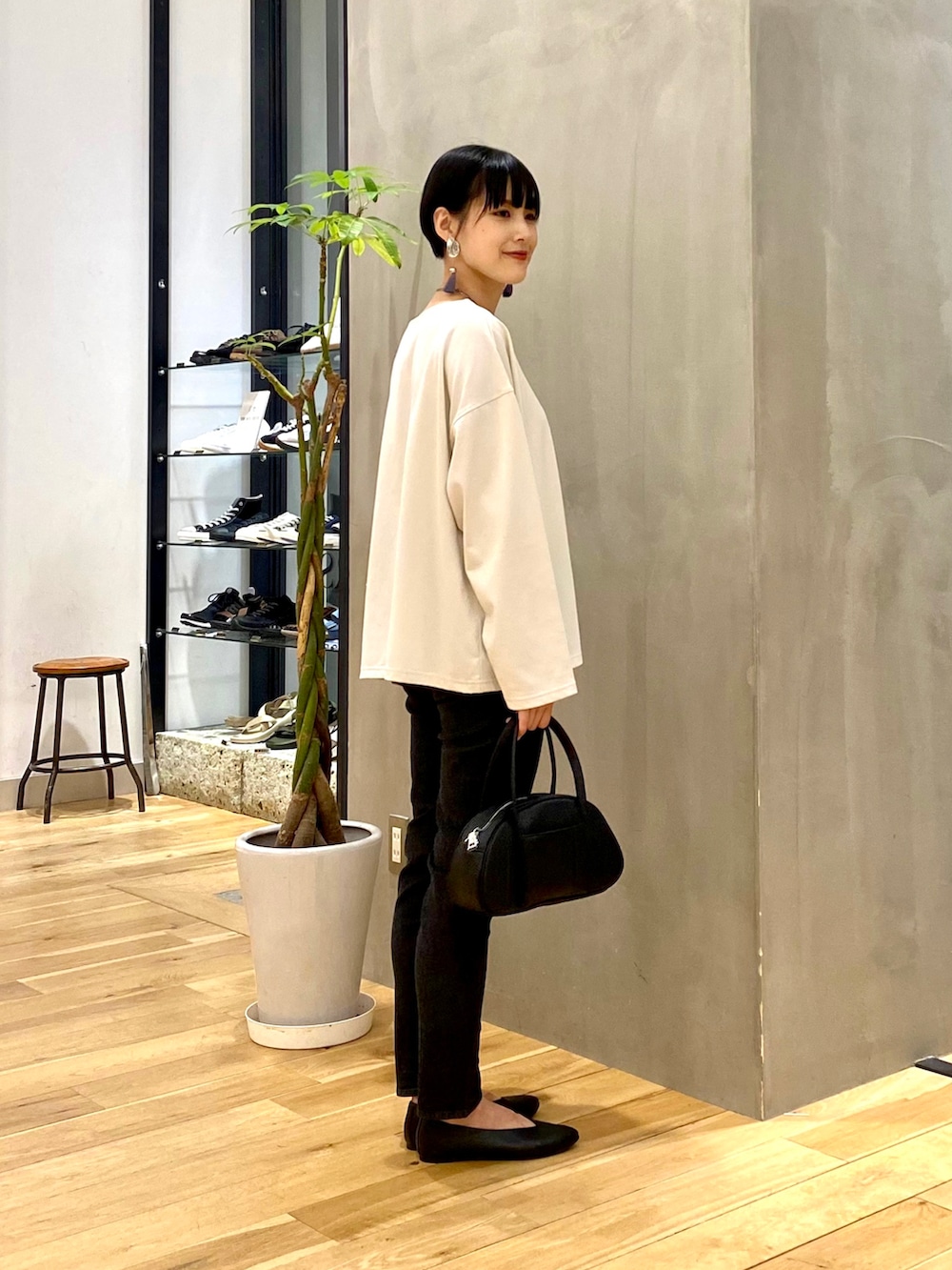 ホワイト系のTシャツ/カットソー、ブラック系のデニムパンツ、ブラック系のショルダーバッグを着用したレディースの秋コーディネートの4枚目の写真