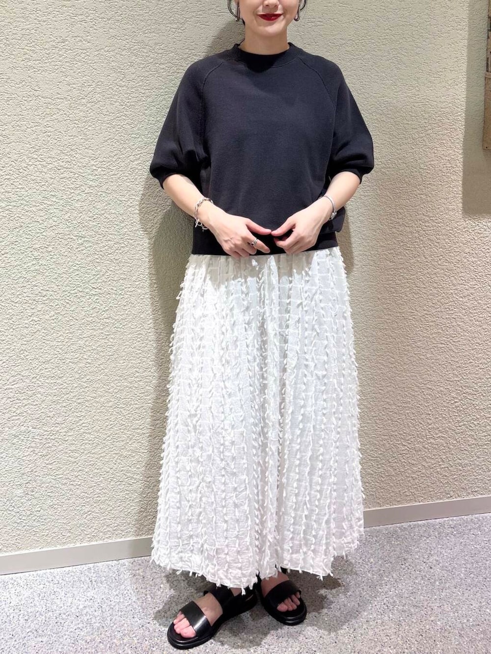 ホワイト系のスカート、グレー系のスウェットを着用したレディースの春コーディネートの4枚目の写真