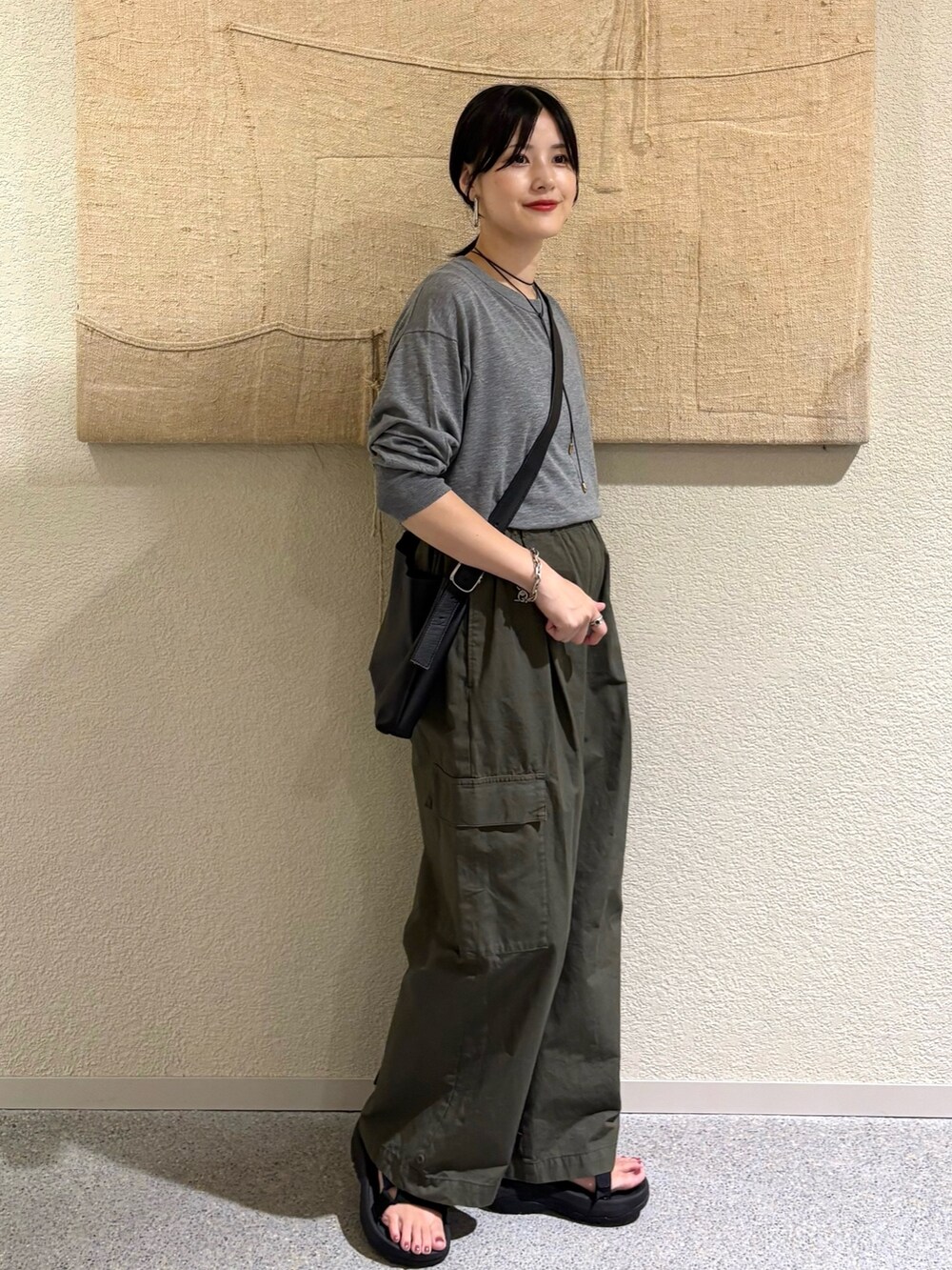 グレー系のニット/セーター、グリーン系のその他パンツを着用したレディースの夏コーディネートの2枚目の写真