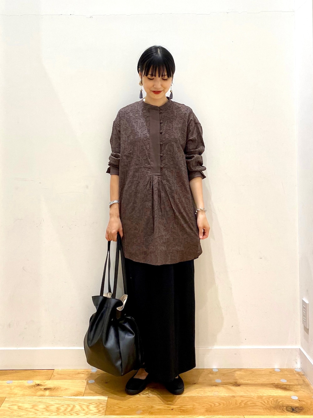 ブラウン系のシャツ/ブラウス、ブラック系のスカート、ブラック系のトートバッグを着用したレディースの夏コーディネートの2枚目の写真