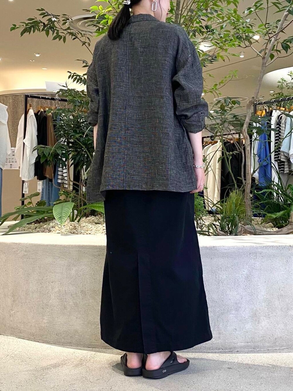 ブラック系のスカート、ブラック系のテーラードジャケット、ブラック系のタンクトップを着用したレディースの夏コーディネートの6枚目の写真