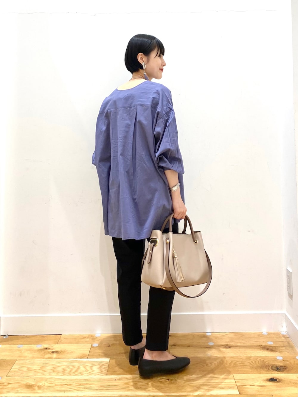 ブルー系のシャツ/ブラウス、ブラック系のその他パンツ、パープル系のトートバッグを着用したレディースの春コーディネートの3枚目の写真