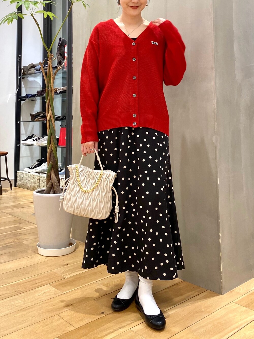 レッド系のカーディガン/ボレロ、ブラック系のスカートを着用したレディースの冬コーディネートの3枚目の写真