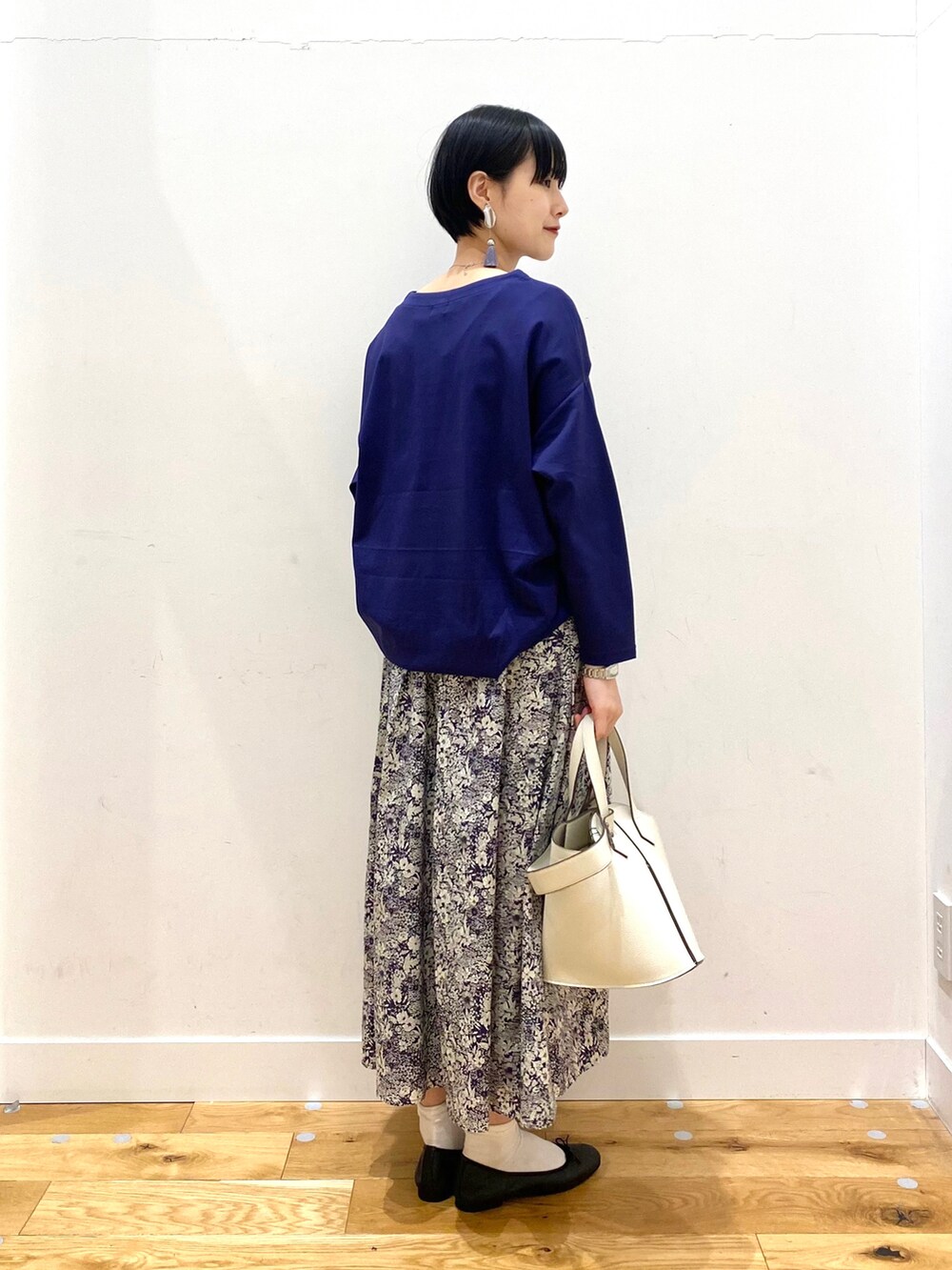ブルー系のTシャツ/カットソー、ブルー系のスカート、ホワイト系のショルダーバッグを着用したレディースの春コーディネートの4枚目の写真