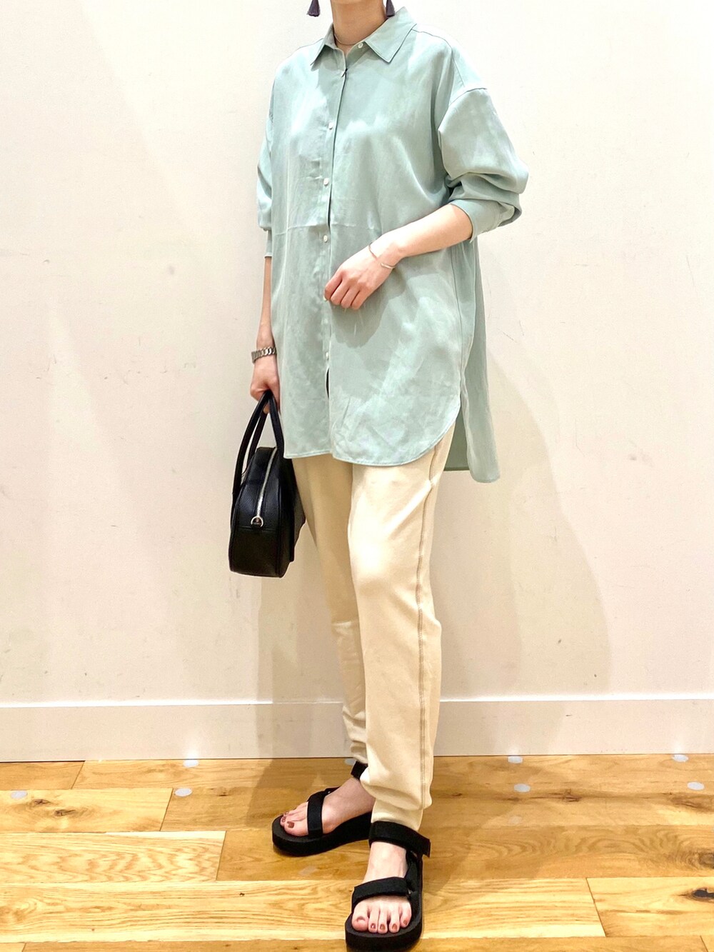 グリーン系のシャツ/ブラウス、ホワイト系のその他パンツ、ブラック系のショルダーバッグを着用したレディースの春コーディネートの4枚目の写真