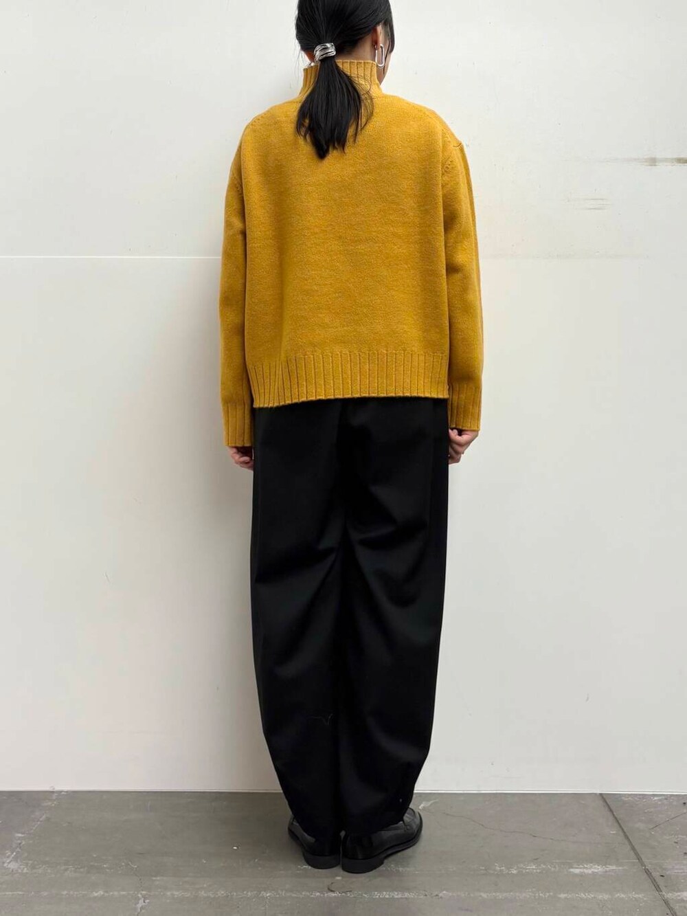 ブラック系のローファー、イエロー系のニット/セーター、ブラック系のその他パンツを着用したレディースの冬コーディネートの9枚目の写真