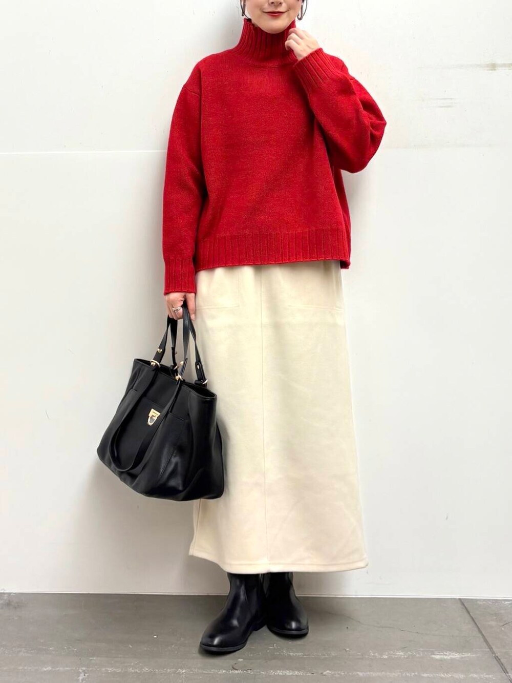 ブラック系のトートバッグ、ブラック系のブーツ、ホワイト系のスカートを着用したレディースの冬コーディネートの4枚目の写真