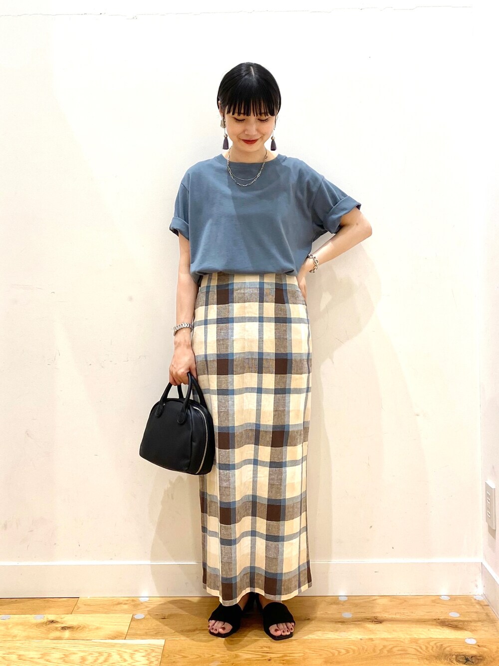 ブルー系のTシャツ/カットソー、ブルー系のスカート、ブラック系のボストンバッグを着用したレディースの夏コーディネートの2枚目の写真