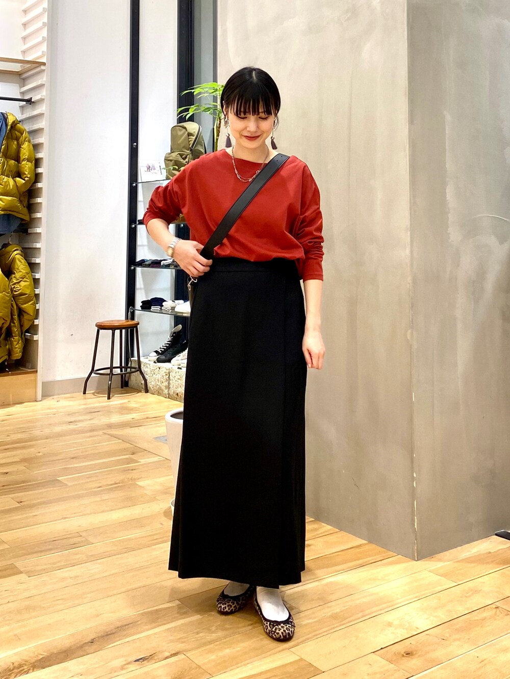 ベージュ系のダウンジャケット/コート、レッド系のTシャツ/カットソー、ブラック系のスカートを着用したレディースの秋コーディネートの3枚目の写真