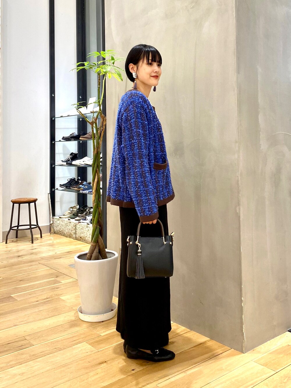 ブルー系のカーディガン/ボレロ、ホワイト系のTシャツ/カットソー、ブラック系のスカートを着用したレディースの秋コーディネートの2枚目の写真