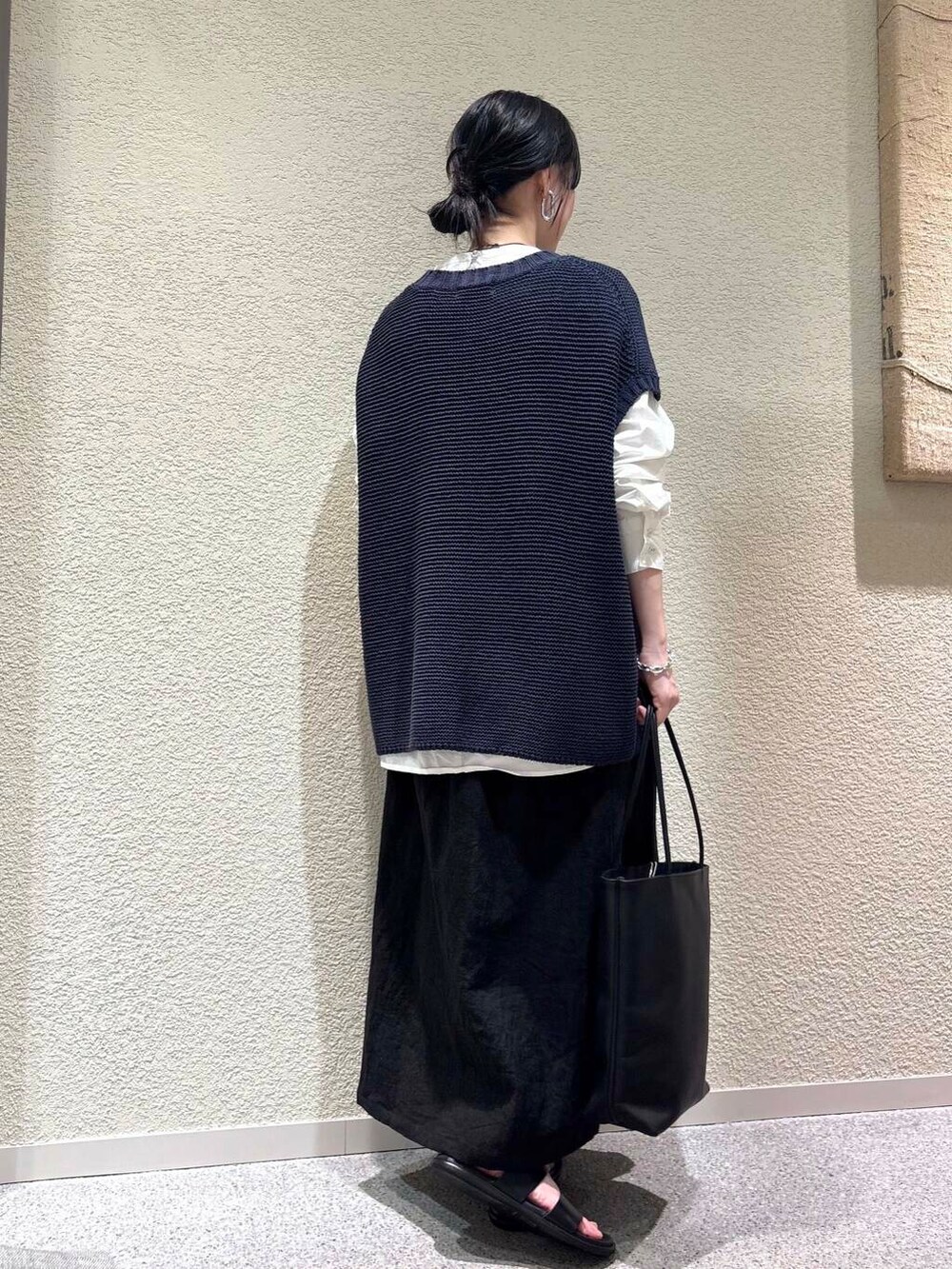 ホワイト系のシャツ/ブラウス、ブルー系のベスト、ブラック系のスカートを着用したレディースの春コーディネートの3枚目の写真