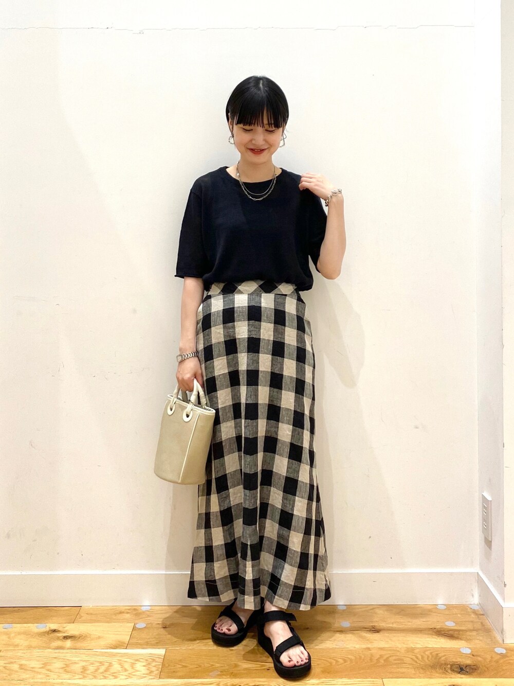 ブラック系のTシャツ/カットソー、その他のスカート、ベージュ系のショルダーバッグを着用したレディースの夏コーディネートの2枚目の写真