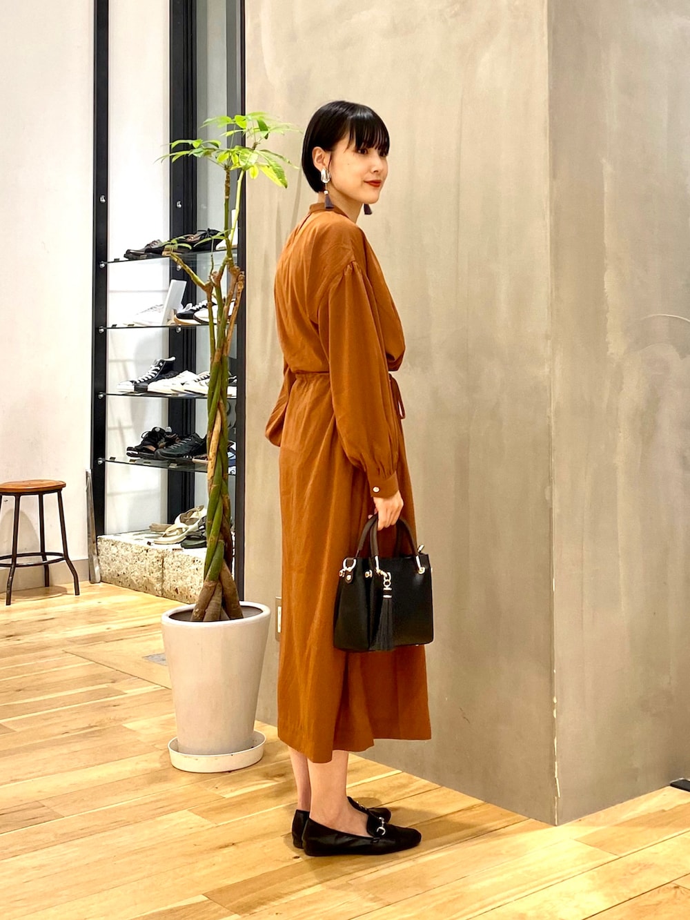 ベージュ系のマウンテンパーカー、イエロー系のワンピース、ブラック系のトートバッグを着用したレディースの秋コーディネートの4枚目の写真