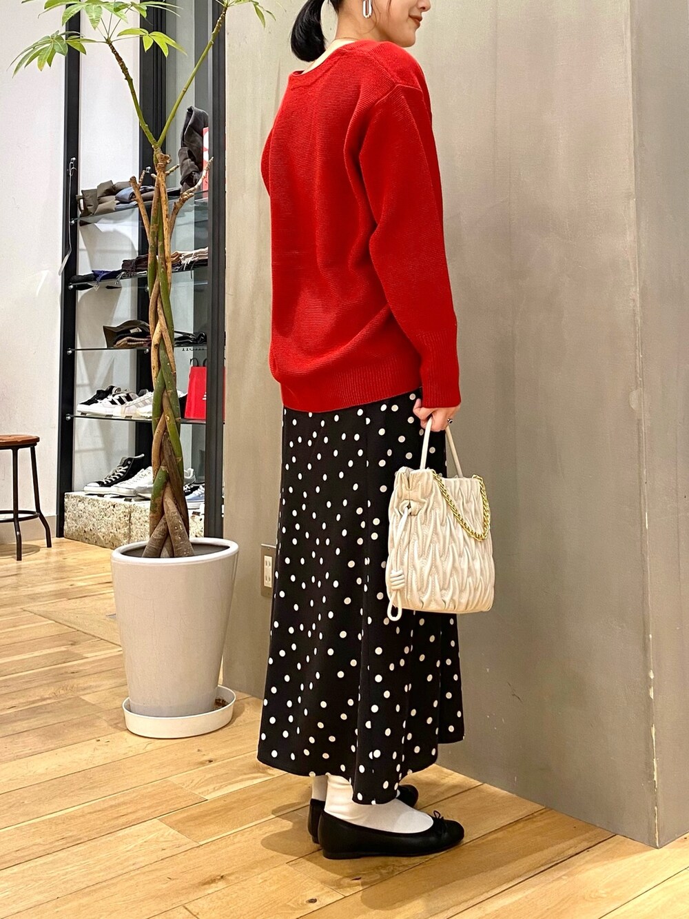 レッド系のカーディガン/ボレロ、ブラック系のスカートを着用したレディースの冬コーディネートの4枚目の写真