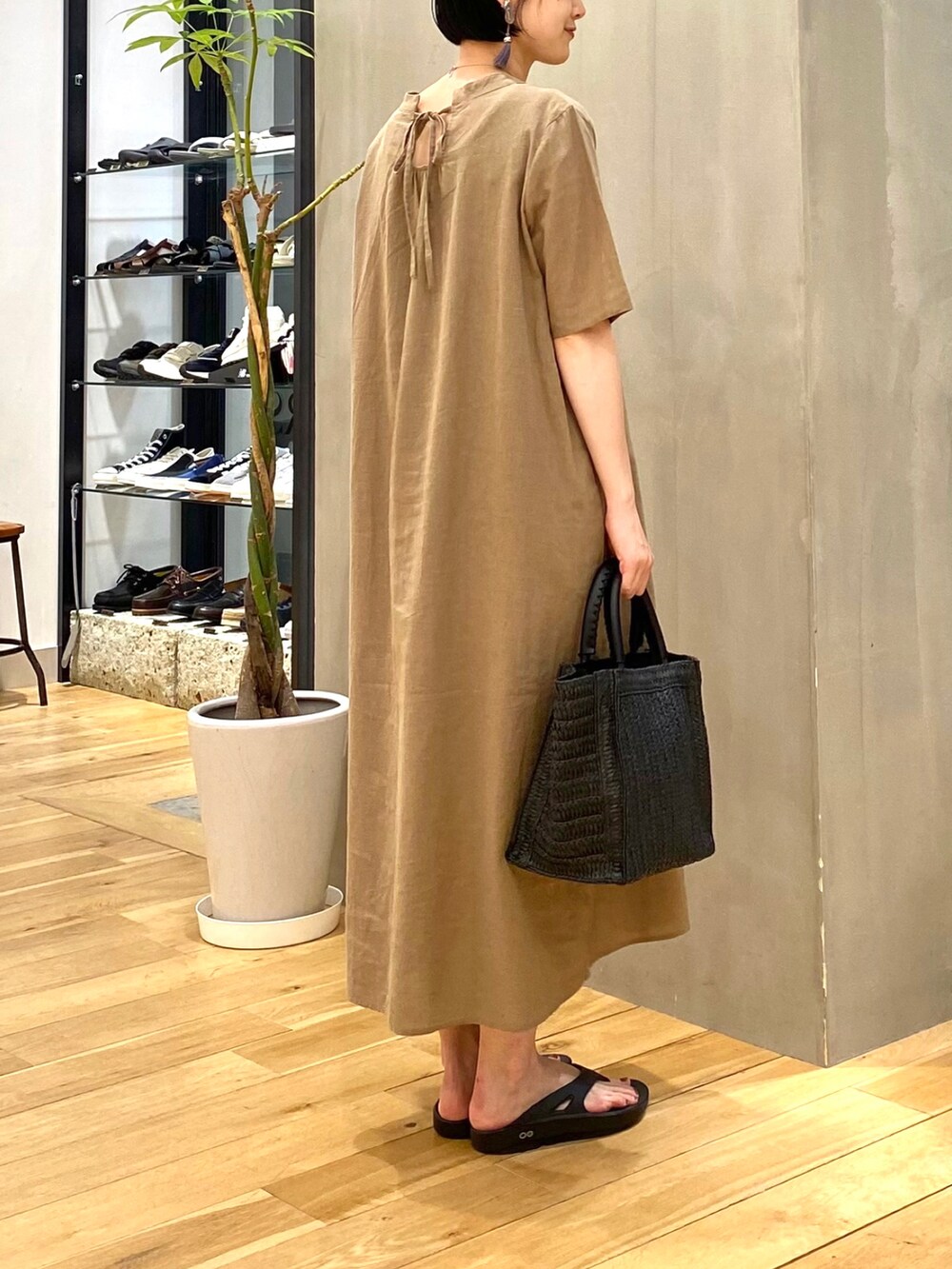 ベージュ系のワンピース、ブラック系のトートバッグ、ブラック系のサンダルを着用したレディースの春コーディネートの5枚目の写真