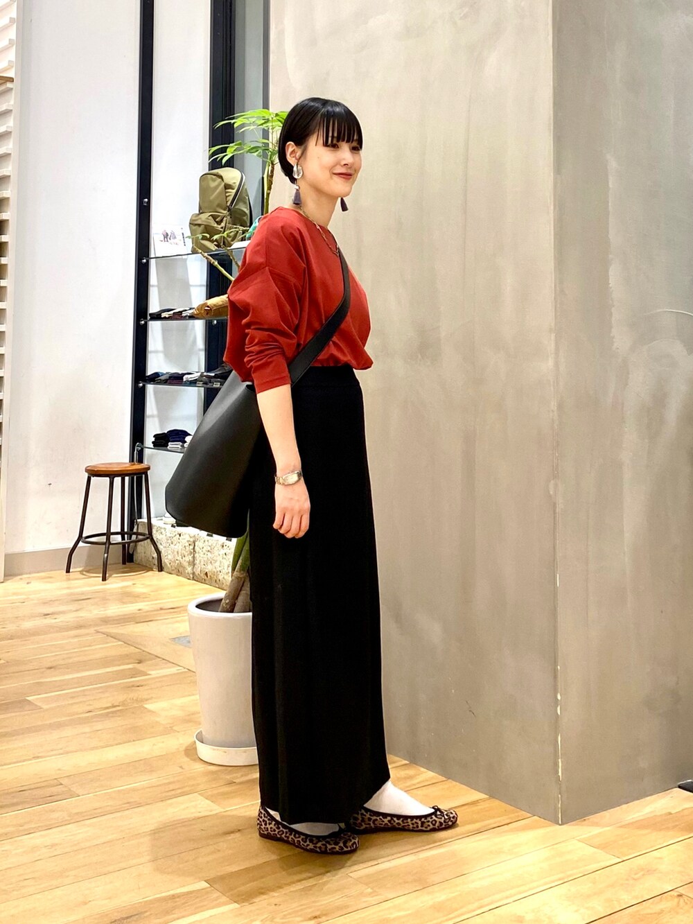 ベージュ系のダウンジャケット/コート、レッド系のTシャツ/カットソー、ブラック系のスカートを着用したレディースの秋コーディネートの4枚目の写真