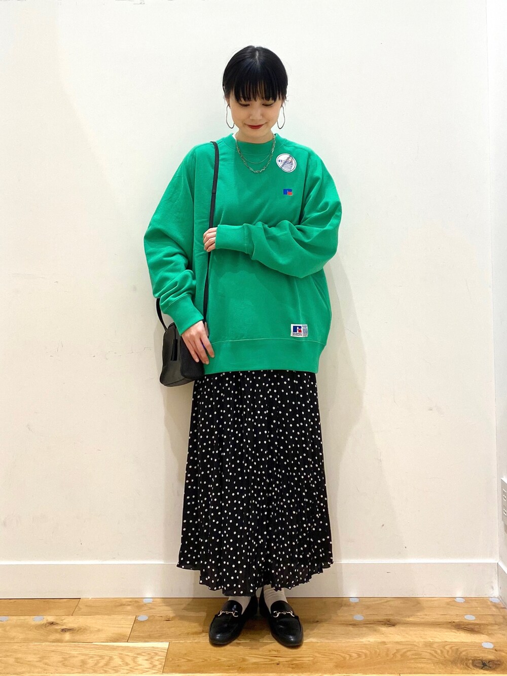 グリーン系のスウェット、ブラック系のスカート、ブラック系のボストンバッグを着用したレディースの冬コーディネートの3枚目の写真