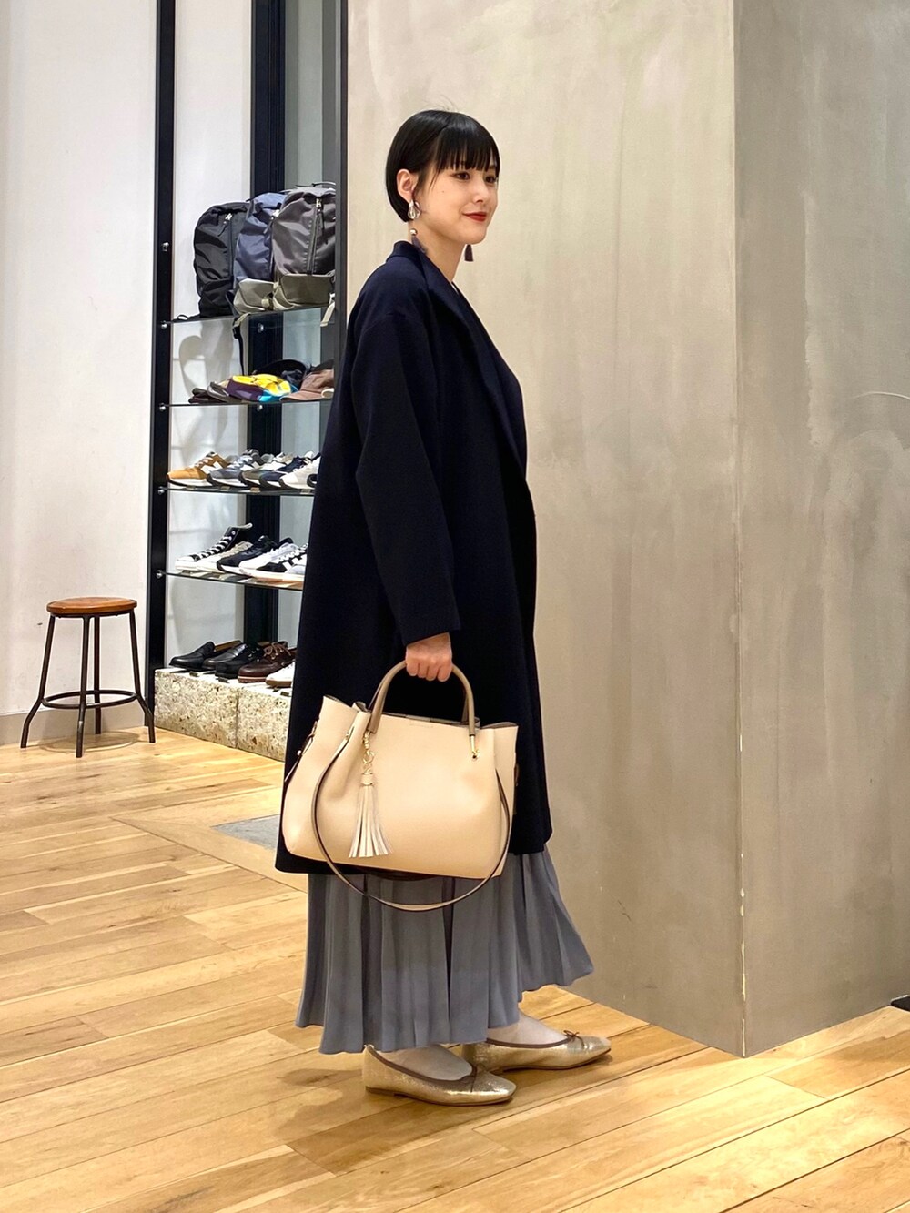 ブルー系のその他アウター、ホワイト系のニット/セーター、ブルー系のスカートを着用したレディースの春コーディネートの2枚目の写真