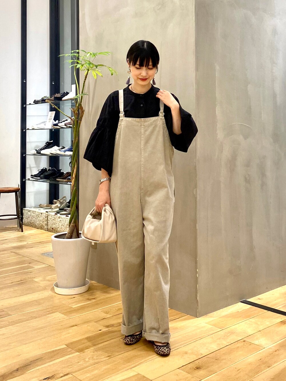 ブラック系のシャツ/ブラウス、グレー系のサロペット/オーバーオール、ホワイト系のショルダーバッグを着用したレディースの秋コーディネートの2枚目の写真