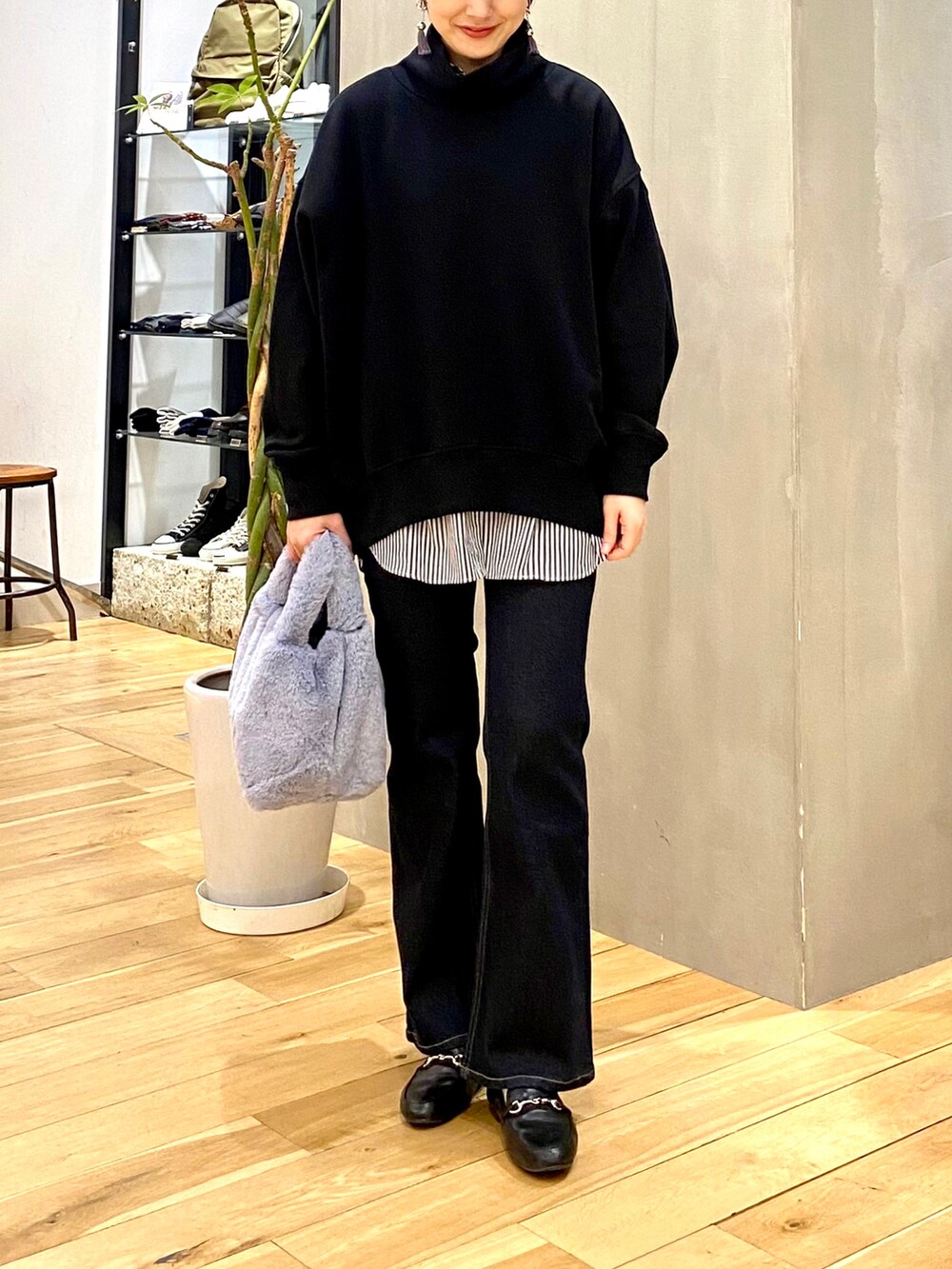 ブラック系のスウェット、ブルー系のシャツ/ブラウス、ブルー系のデニムパンツを着用したレディースの冬コーディネートの4枚目の写真