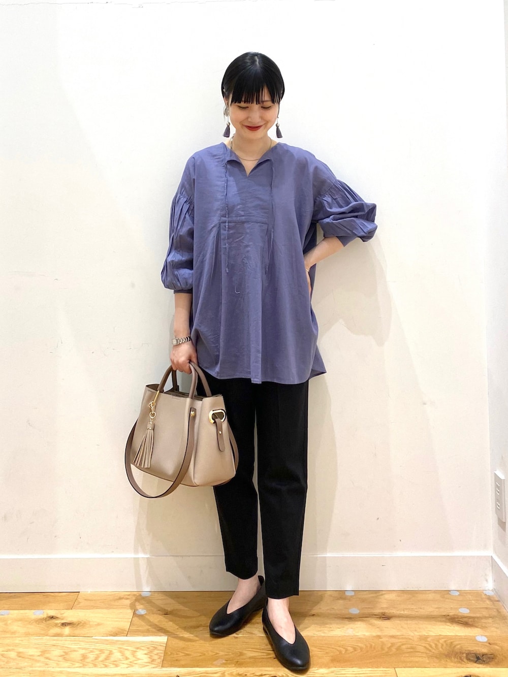 ブルー系のシャツ/ブラウス、ブラック系のその他パンツ、パープル系のトートバッグを着用したレディースの春コーディネートの2枚目の写真