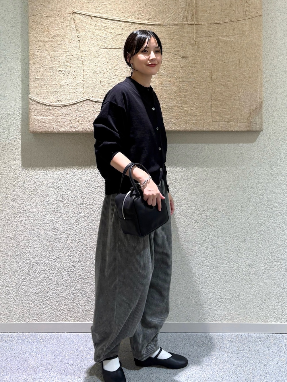 ブラック系のカーディガン/ボレロ、ブラック系のバレエシューズ、ブラック系のトートバッグを着用したレディースの秋コーディネートの2枚目の写真