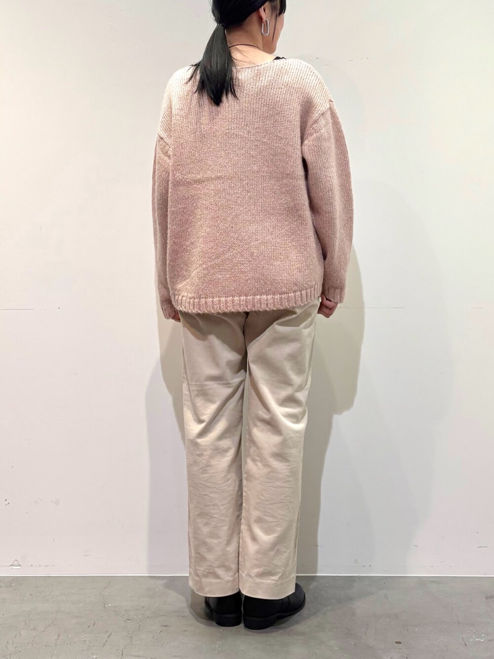 ピンク系のニット/セーター、ホワイト系のその他パンツ、ブラック系のブーツを着用したレディースの冬コーディネートの7枚目の写真