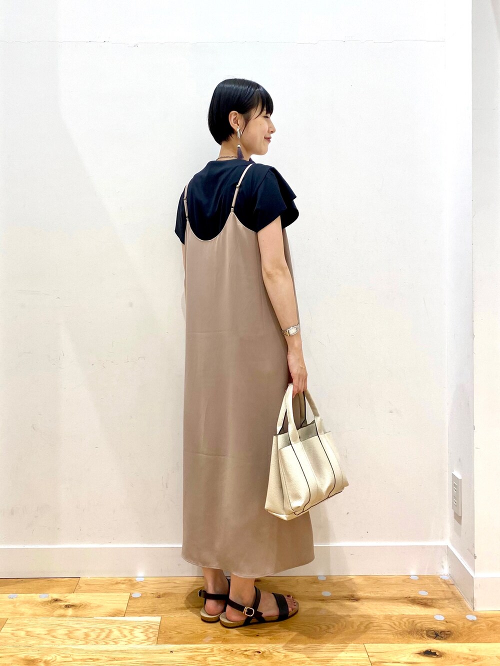 ブラック系のTシャツ/カットソー、ベージュ系のワンピース、ホワイト系のトートバッグを着用したレディースの夏コーディネートの3枚目の写真