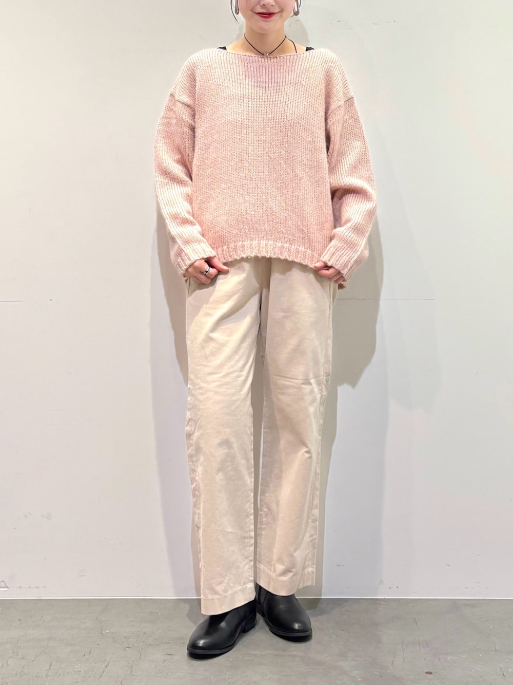 ピンク系のニット/セーター、ホワイト系のその他パンツ、ブラック系のブーツを着用したレディースの冬コーディネートの5枚目の写真