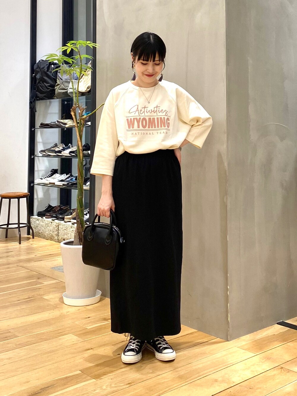 グレー系のノーカラージャケット、ホワイト系のTシャツ/カットソー、ブラック系のスカートを着用したレディースの春コーディネートの3枚目の写真