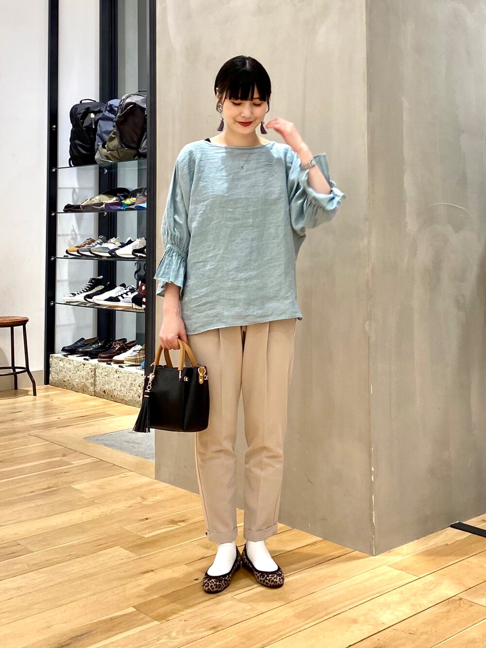 グリーン系のシャツ/ブラウス、ベージュ系のその他パンツ、ブラック系のトートバッグを着用したレディースの春コーディネートの2枚目の写真