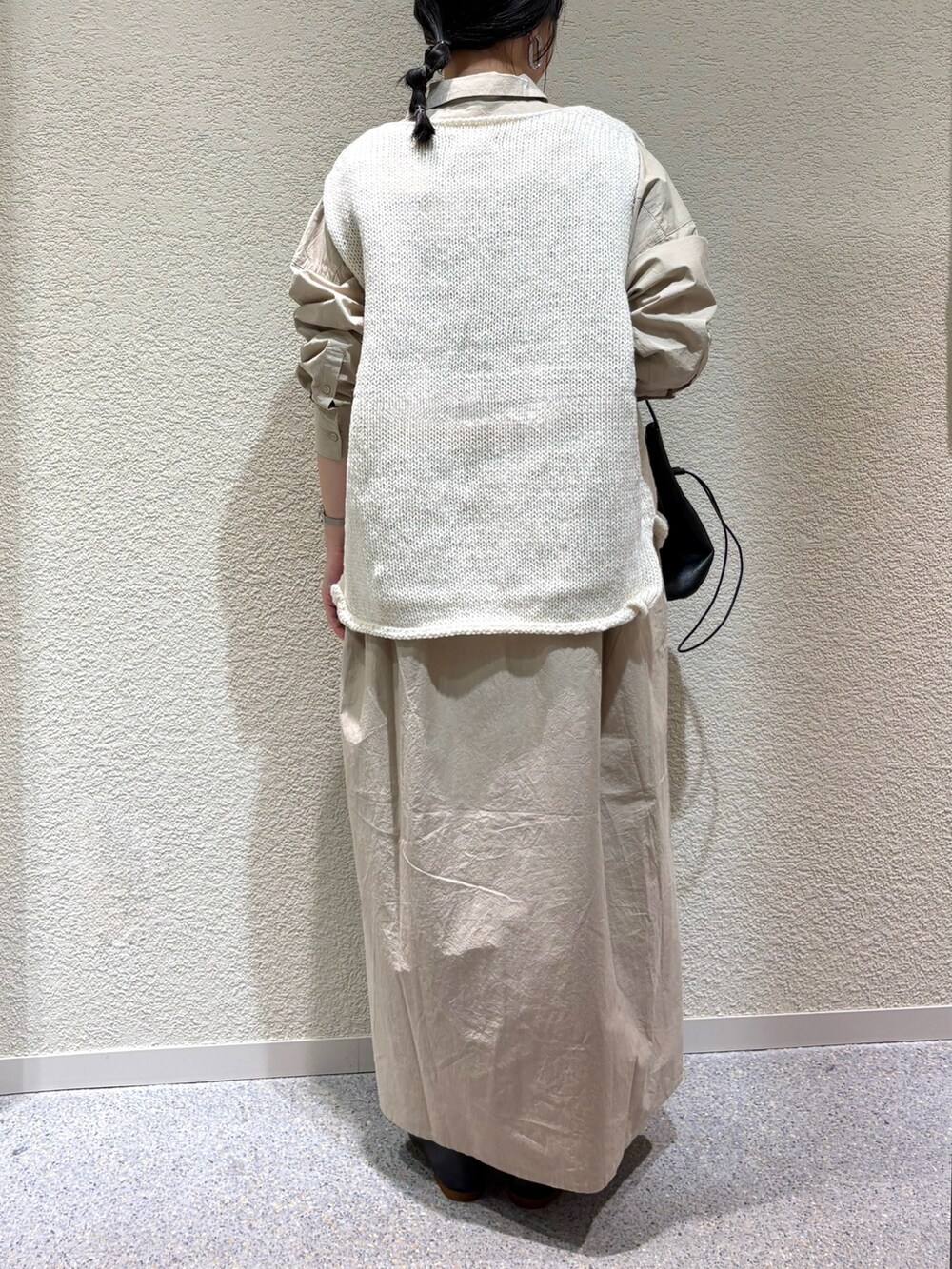 ベージュ系のワンピース、ホワイト系のニット/セーター、ブラック系のバレエシューズを着用したレディースの秋コーディネートの5枚目の写真